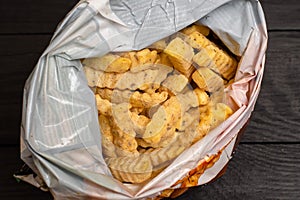 Frozen fries with spices in a plastic bag. Semifinished