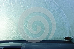 A frozen  front windshield of a car from inside view