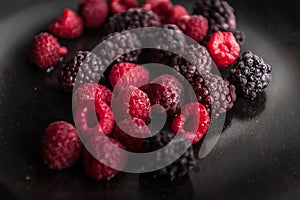 Frozen fruits on a black plate