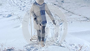 Frozen funny woman dragging sledge outdoor