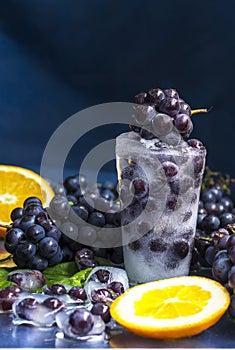 Frozen grapes in ice with orange close-up