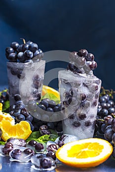 Frozen grapes in ice with orange close-up