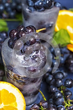 Frozen grapes in ice with orange close-up