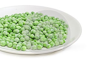 Frozen green peas on the white dish with selective focus