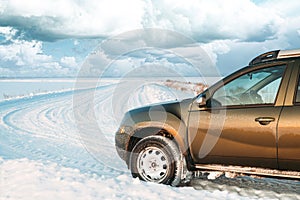 Frozen And Grungy SUV Car Parked On Winter Snowy Field Countryside Landscape. Altered Sky