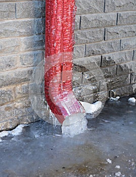 Frozen Gutter, Downspout. Gutter Pipe, Downspouts, House Foundation Wall Sometimes Freeze into Solid Blocks of Ice. Bad rain