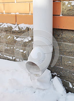 Frozen Gutter, Downspout Pipeline with Ice. Gutters frozen solid.