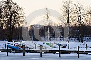 Frozen harbor in winter with snow covered boats photo