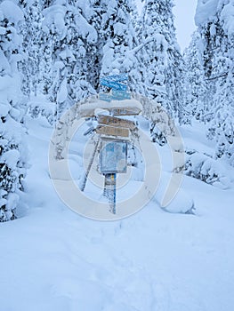 Frozen hiking signage in a winter snowy forest, Finnish Lapland