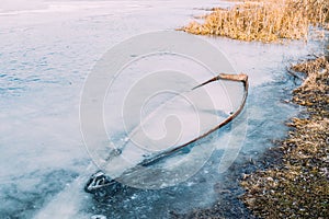 Frozen Into Ice Of River, Lake, Pond Old Forsaken Wooden Boat. A