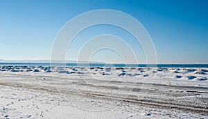 Frozen ice and sand dunes on beach in winter.