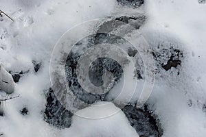 Frozen ice shape over fluent water in river