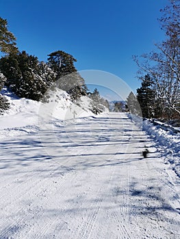 Frozen icy dangerous road in winter. Blue clear sky.