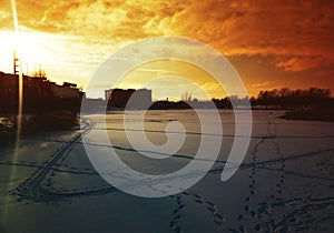 Frozen industrial pond during dramatic sunset