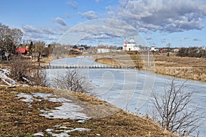 Frozen Kamenka River and Wooden Walking Bridge in Springtime