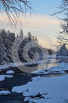 Frozen Kiiminki river Koiteli rapids and sunset on cold winter afternoon.