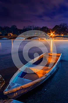 Frozen lake with a boat in the winter shot during night in a par