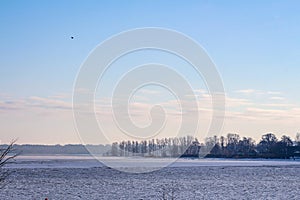 Frozen lake on the chilly day few hours before sunset.