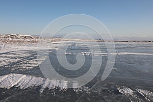 Frozen lake and flat landscape with blue skies