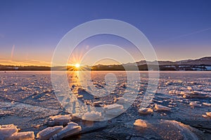 Frozen Lake with Ice Floes in Winter Landscape during Sunrise, Bavaria, Germany