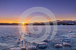 Frozen Lake with Ice Floes in Winter Landscape during Sunrise, Bavaria, Germany