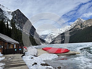 Frozen Lake Louise Lake in Banff National Park with the red canoes