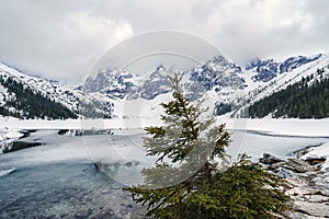 Frozen lake Morskie Oko and stunning mountains in Tatra national park, Poland. Scenic winter landscape, travel background