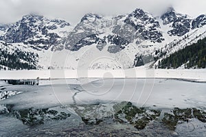 Frozen lake Morskie Oko and stunning mountains in Tatra national park, Poland. Scenic winter landscape, travel background