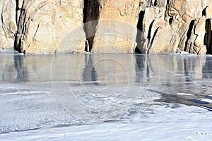 Frozen lake next to a mountain