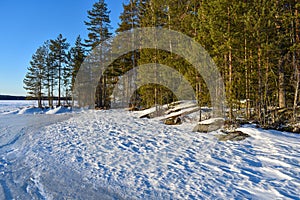 Frozen lake on a rocky shore of the forest