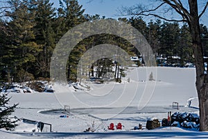 Frozen lake, snow and forest. Hokey field on water photo