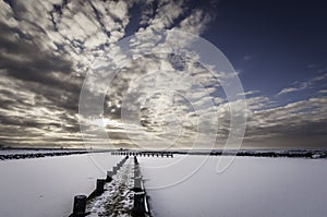 Frozen lake at sunset viewed form a pier.