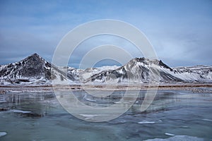 Frozen Lake Surrounded By Snow Covered Mountains 