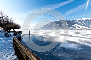 Frozen lake Zeller and snowy mountains in Austria