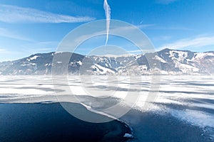 Frozen lake Zeller and snowy mountains in Austria