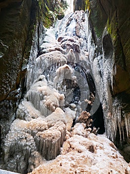 Frozen Large waterfall in Teplice Adrspach Rocks park during winter season. Eastern Bohemia, Czech Republic