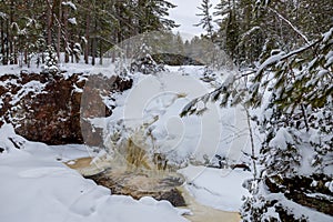 Frozen Little Manitou Falls with fresh snow during winter at Pattison State Park in Superior Wisconsin