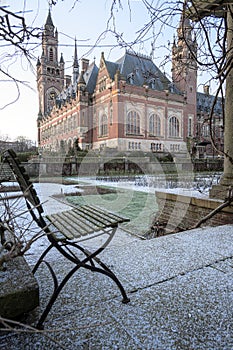Frozen lonely chair at Peace Palace garden, International Court of Justice, under the Snow