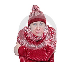 Frozen man in red sweater, scarf and hat warming hands, isolated on white background. File contains a path to isolation.