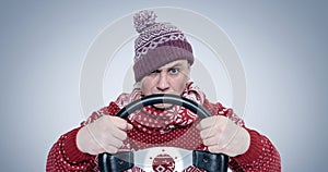 Frozen Man in sweater and hat with a steering wheel. Concept car driver