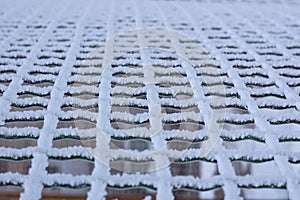 Frozen metal iron net chequer covered with frost in winter