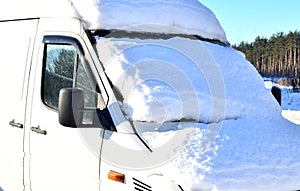 Frozen minibus covered with snow on a winter day after a snowfall, view of the windshield of the front window
