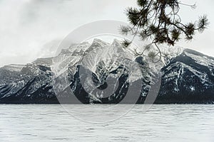 Frozen Minnewanka Lake surrounded by Canadian Rocky Mountains. photo