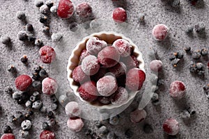 Frozen mix berries red sour cherry and black currant on gray background. View from above.