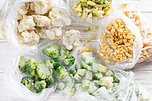 Frozen mixed vegetables in a bag on white wooden table. Frozen food. Top view