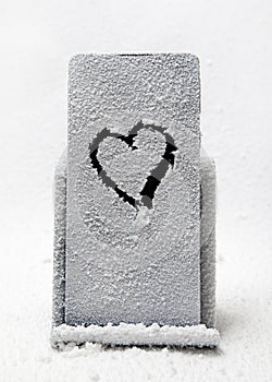 Frozen mobile phone on a stand with a painted heart.
