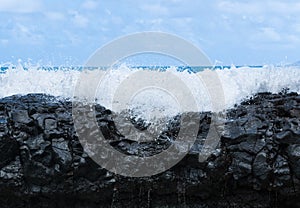 Frozen motion of ocean waterfall over rocks at Lumahai Beach