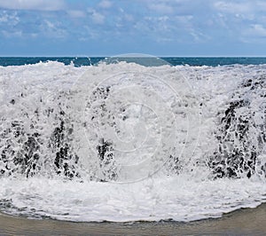 Frozen motion of ocean waterfall over rocks at Lumahai Beach