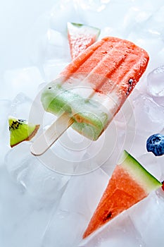 Frozen natural vanilla watermelon smoothies on a stick on ice cubes. Ice lolly. Top view