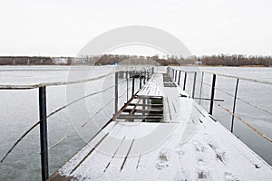 Frozen old pier at river side.